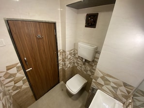 Ein Badezimmer mit Holztür, Toilette und Waschbecken.