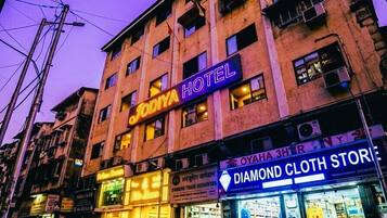 A hotel with a sign reading 'JODIYA HOTEL' and a store named 'DIAMOND CLOTH STORE' across the street.