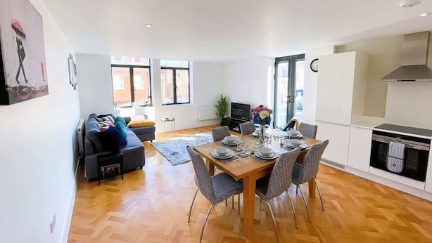 A modern apartment with a dining area, kitchen, and living room.