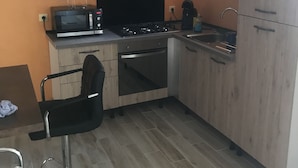 Eine kleine Küche mit Mikrowelle, Herd, Backofen und Spüle.