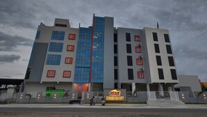 A multi-story building with a modern architectural design, featuring a prominent vertical red stripe and a sign that reads "EVEREST RESIDENCY". - Treebo Everest Residency Tidel Park (Coimbatore)