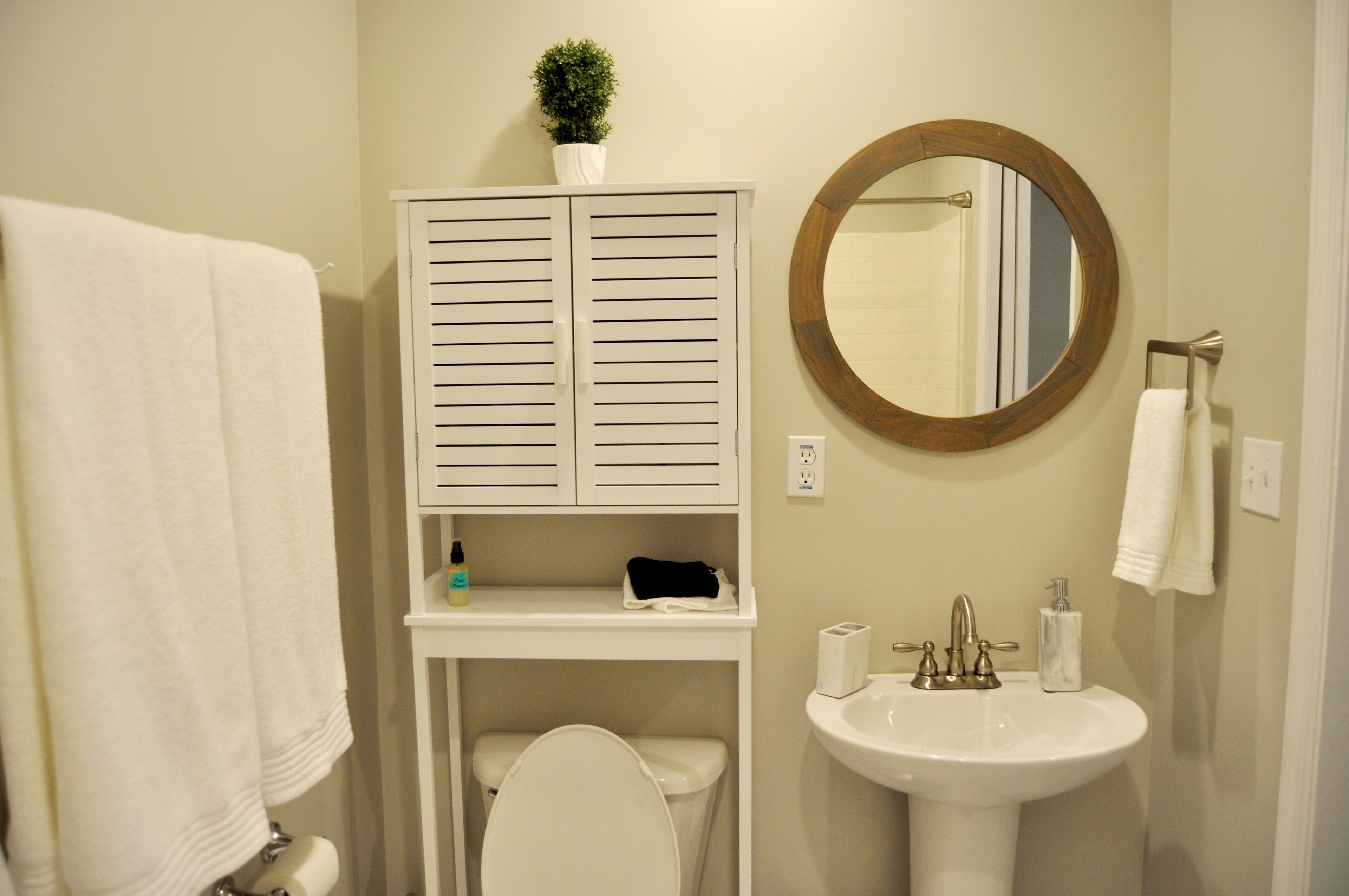 Une salle de bain comprenant des toilettes, un lavabo et un meuble avec un miroir au-dessus.