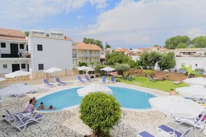 Relax by the clear pool surrounded by lush greenery and comfortable lounge chairs.