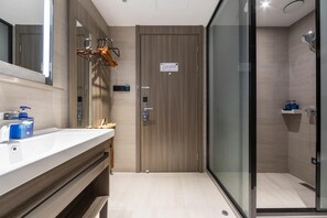 A modern bathroom with a wooden vanity, a glass shower enclosure, and a mirror. - Hanting Hotel(ecust Shanghai South Railway Station (Shanghai)