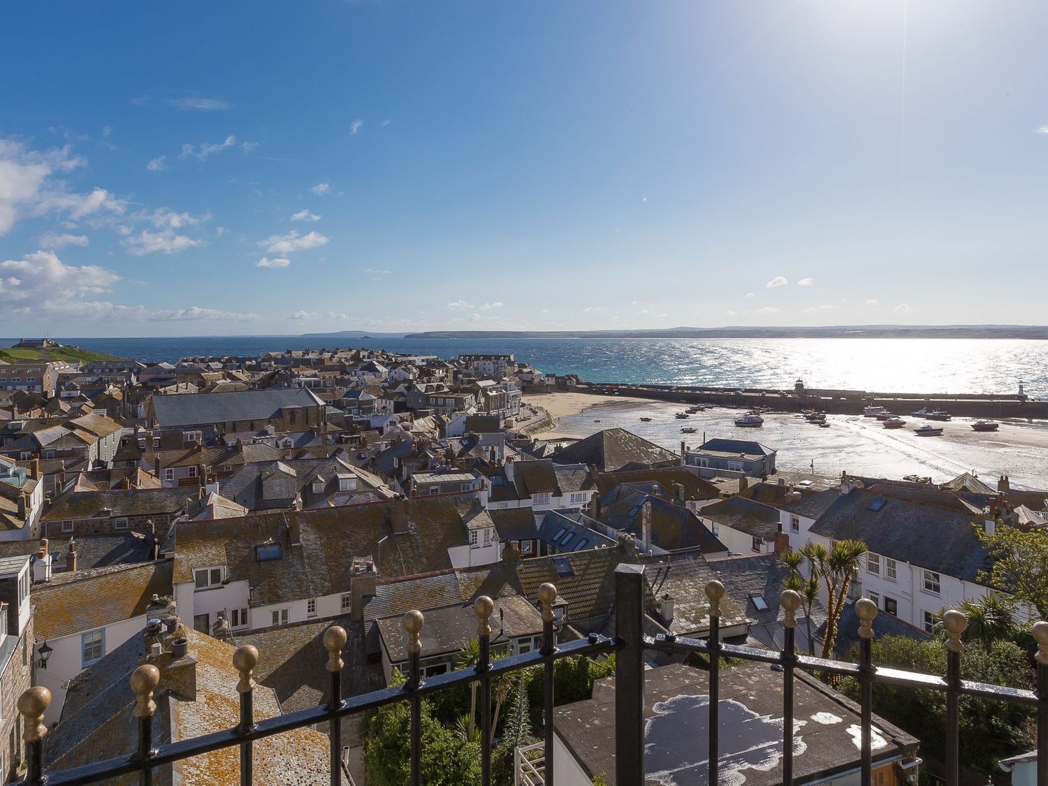 A coastal town with historic buildings, a beach, and boats.
