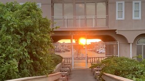 A wooden bridge leading to a building with a balcony and a sign that reads "Diploma".