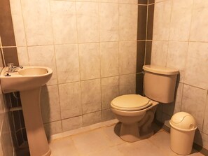 Ein Badezimmer mit Waschbecken, Toilette und Mülleimer.