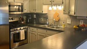 Una cocina moderna con electrodomésticos de acero inoxidable, armarios blancos y una isla grande con fregadero.
