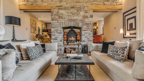 A cozy living room with a stone fireplace, two sofas, a coffee table, and a lamp. - Hilltop View with Hot Tub (Brecon)