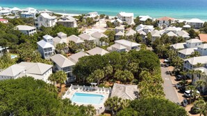 Un quartier résidentiel situé sur la côte, avec des maisons, une piscine et une vue sur l’océan.