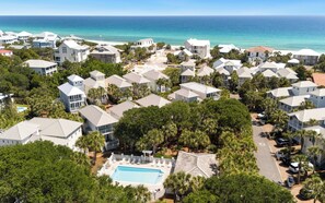 A coastal residential area with houses, a swimming pool, and a view of the ocean.