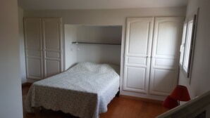 Ein Schlafzimmer mit einem Bett, einem Kleiderschrank und einer roten Lampe.