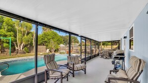 A covered patio with a pool, outdoor furniture, and a grill area. - Relax and Unwind in 2 BR apt with Private Heated Pool (Sebastian)