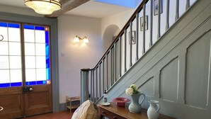 A staircase with a wooden handrail and a wall-mounted light fixture. - Frizenham Farmhouse B&B (Torrington)
