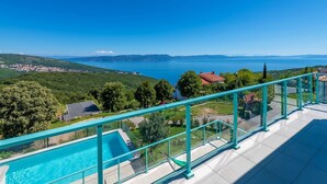 A balcony with a pool overlooking a coastal landscape. - Villa with exceptional views (Labin)