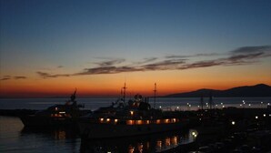 Un puerto deportivo al atardecer con varias embarcaciones amarradas.