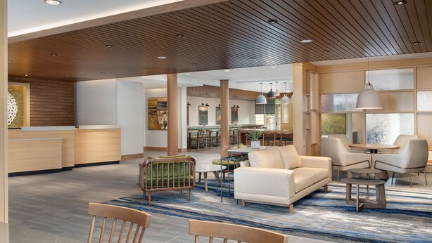A spacious lobby with a wooden ceiling, a reception desk, seating area with sofas and chairs, and a large window providing natural light. - Fairfield Inn & Suites by Marriott Boise West (Boise)