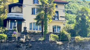 A multi-story building with balconies, a stone staircase, and lush greenery in the background. - Room in Villa, with private bathroom and kitchen use. (Perledo)