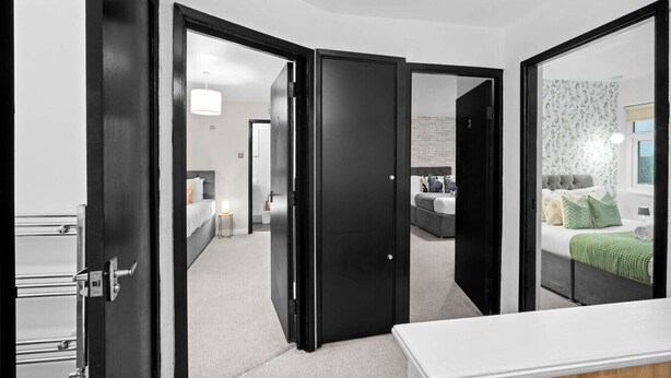 Et moderne hotelværelse med en stor seng, et skrivebord og et walk-in closet.