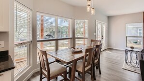 A spacious dining area with a wooden table, chairs, and large windows offering views of the outside. - Canyon Lake Retreat, Pets Welcome. WIFI, 3 blocks from boat ramp 6 (Canyon Lake)