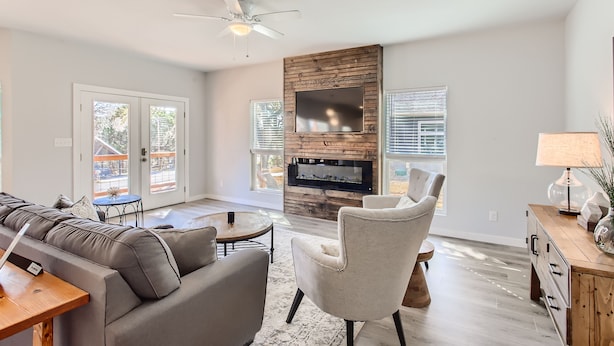A spacious living room with a large sectional sofa, a fireplace, and a ceiling fan. - Canyon Lake Retreat, Pets Welcome. WIFI, 3 blocks from boat ramp 6 (Canyon Lake)