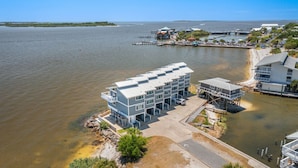 Ein Hotel direkt am Wasser mit modernem Design, mit mehreren Balkonen und einem Steg.