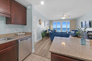 A modern kitchen with granite countertops, stainless steel appliances, and wooden cabinets. - Ocean View- Laketown Wharf 1809 (Panama City Beach)
