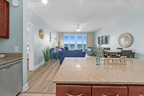 A spacious living area with a kitchen, dining area, and a view of the ocean.