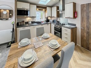 A modern kitchen with a dining area, equipped with a stove, oven, and microwave.