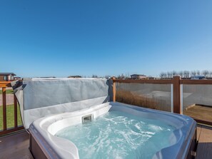 Un bain à remous sur une terrasse, avec en arrière-plan la vue sur des maisons.