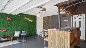 A modern interior with a green wall, seating area, and a bar counter. - THIS MUST BE THE PLACE-House to Beach in 5 minutes (Navarre)