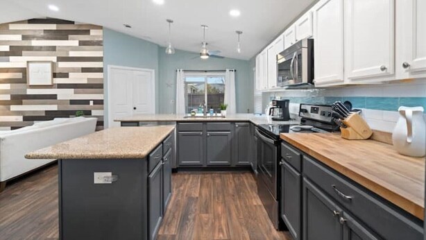 A modern kitchen with dark cabinets, a wooden countertop, and a built-in microwave. - THIS MUST BE THE PLACE-House to Beach in 5 minutes (Navarre)
