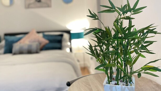 A bedroom with a bed, a bedside table, a lamp, and a wall-mounted TV. - Citywide Hospitality (Liverpool)