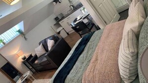 A modern living room with a sofa, a coffee table, and a dining area with a table and chairs. - Citywide Hospitality (Liverpool)