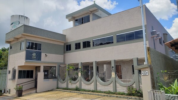 A modern two-story building with a flat roof, large windows, and a gated entrance. - Guest Apartment Village São Jorge (Alto Paraíso de Goiás)