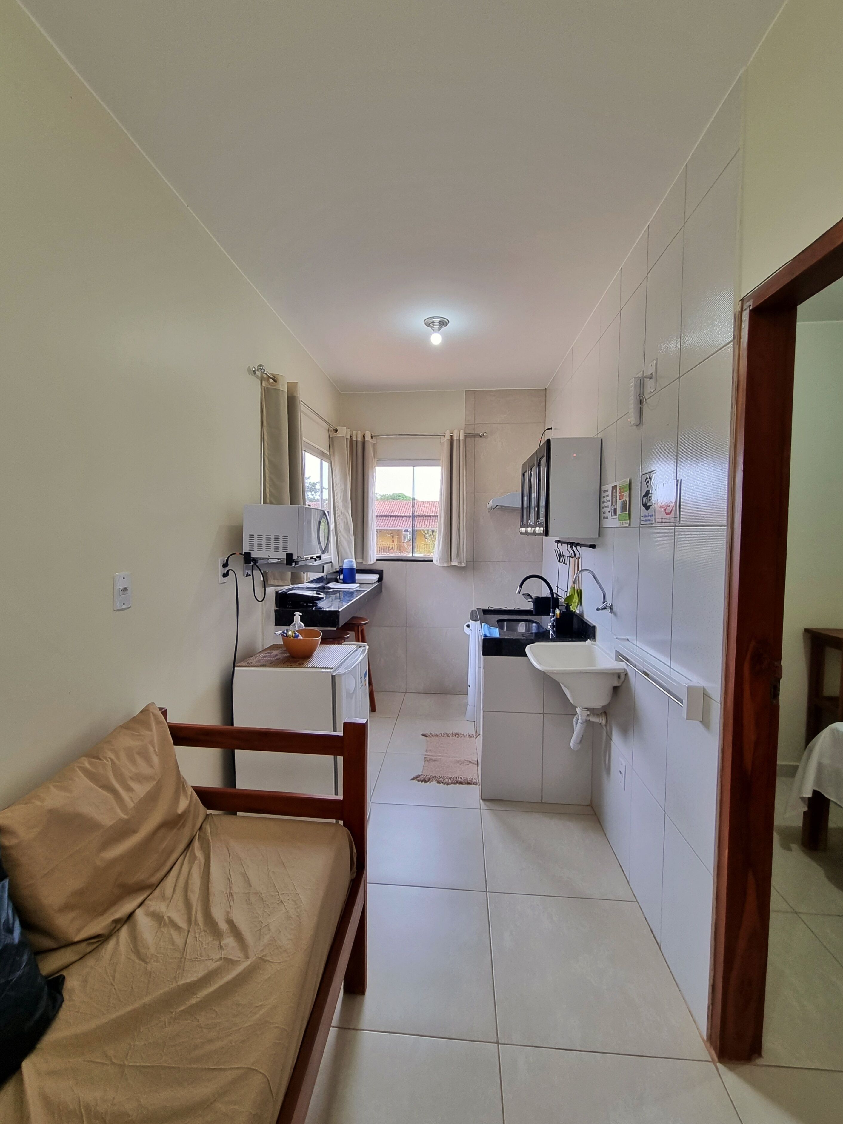 A compact living space with a kitchenette, a sofa, and a small dining area.