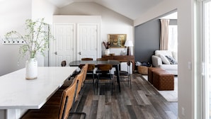 Amplia sala de estar con una mesa de comedor, sillas, un sofá y una mesa de centro.