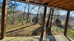 Une structure en bois offrant une vue sur un paysage boisé.