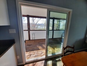 Une pièce dotée d’une porte-fenêtre coulissante donnant sur une terrasse en bois.