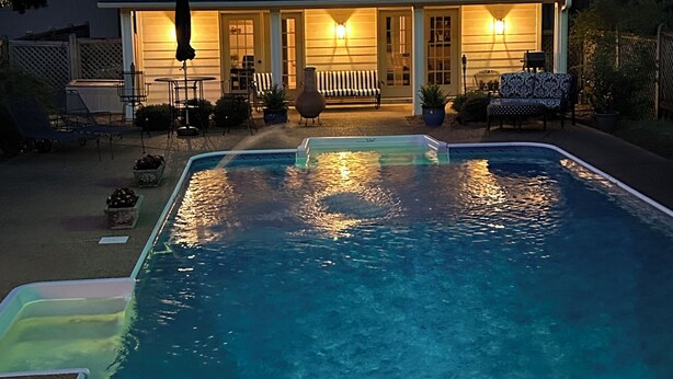 Una piscina con una casa al fondo.