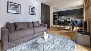 A modern living room with a grey sofa, a coffee table, and two framed pictures on the wall.
