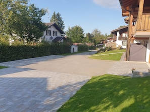 Une rue résidentielle bordée de trottoirs pavés et de maisons.