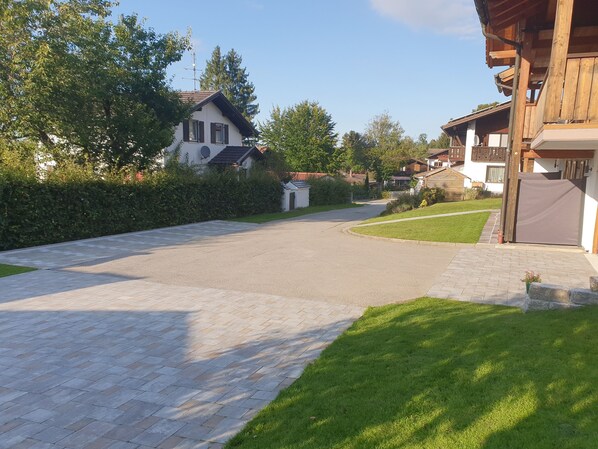 A residential street with paved sidewalks and houses.