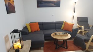Una sala de estar moderna con un sofá modular, una mesa de centro de madera y un sillón individual.