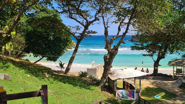 A beach scene with a wooden shack, a small hut, and a lifeguard tower.