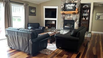 TV connectée, cheminée, table de tennis de table, livres