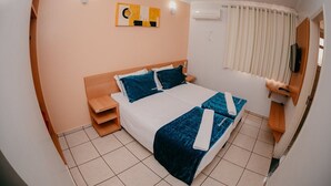 A hotel room with a bed, a nightstand, a wall-mounted TV, and a window with curtains. - Diroma Fiori Hotel - BVTUR (Caldas Novas)