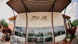 A building with a curved roof and a sign that reads "dR Roma Fiori". - Diroma Fiori Hotel - BVTUR (Caldas Novas)