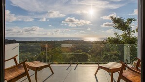 Un balcón con vista al mar y al atardecer.