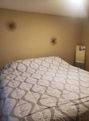 Cozy retreat with a large bed, starburst decorations, and a framed picture.